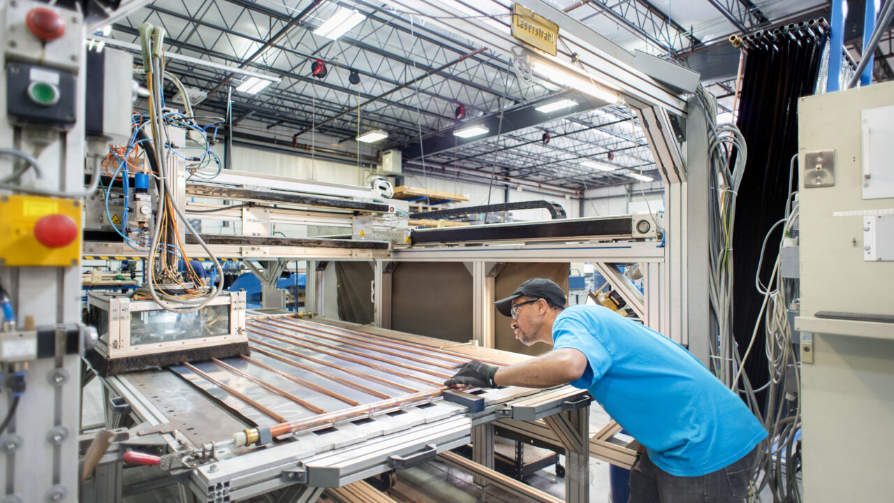 Man in a workshop making a solar panel.