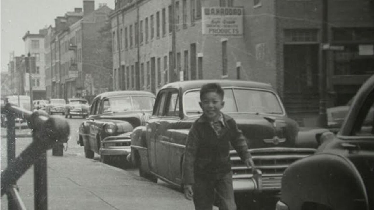 Historic photo of young boy on sidewalk in Boston Chinatown