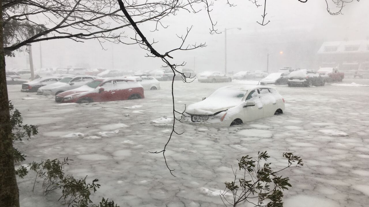 Cars parked by Boston's waterfront are flooded with snow and water