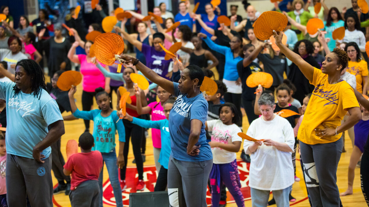 Young kids learn from Alvin Ailey dancers.