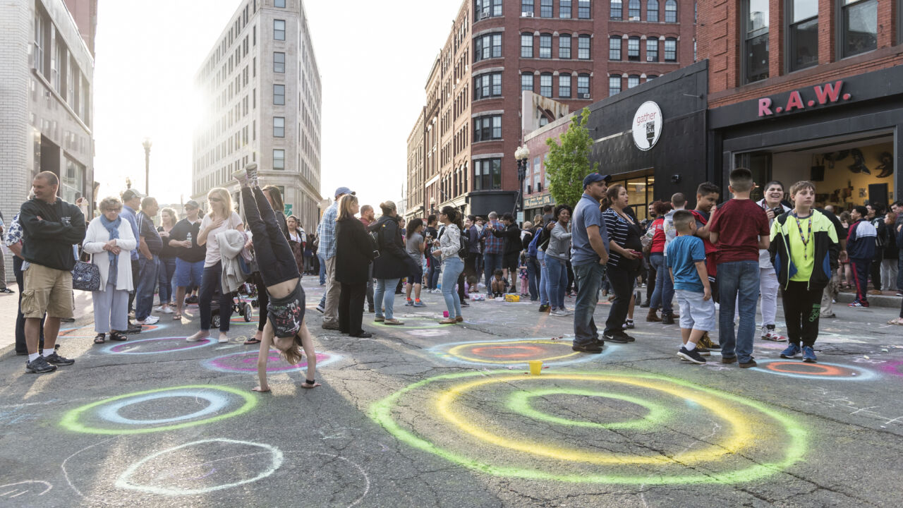 People celebrate outside and make art at a block party.