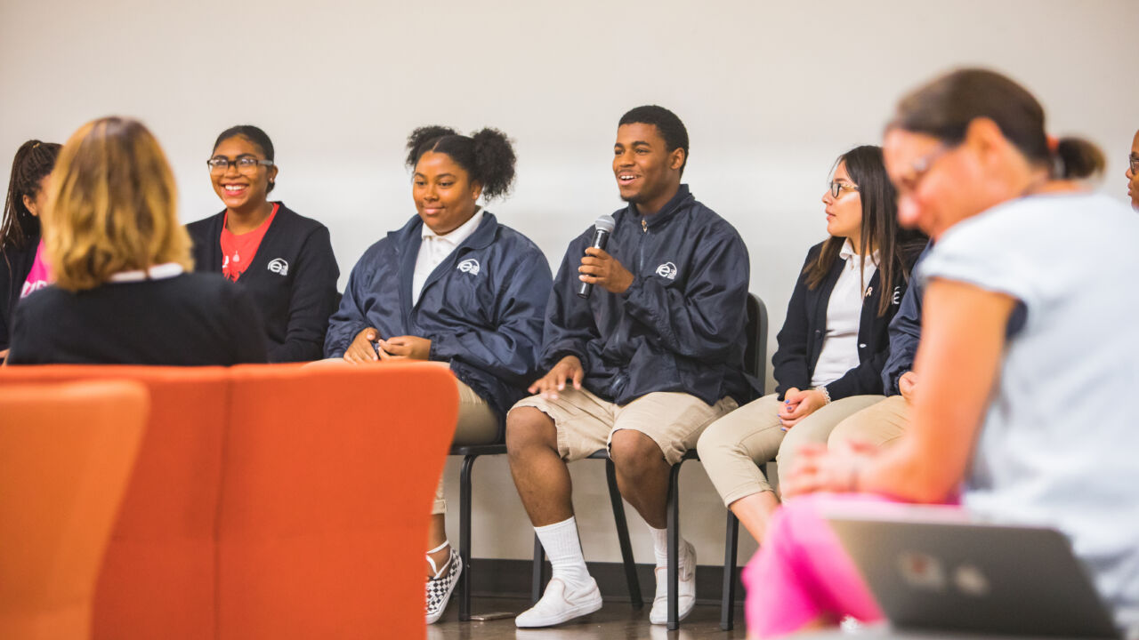Students talk on a panel.
