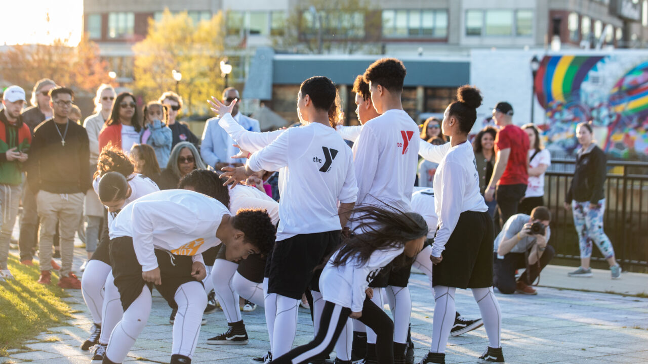 A group of teens dance outside.
