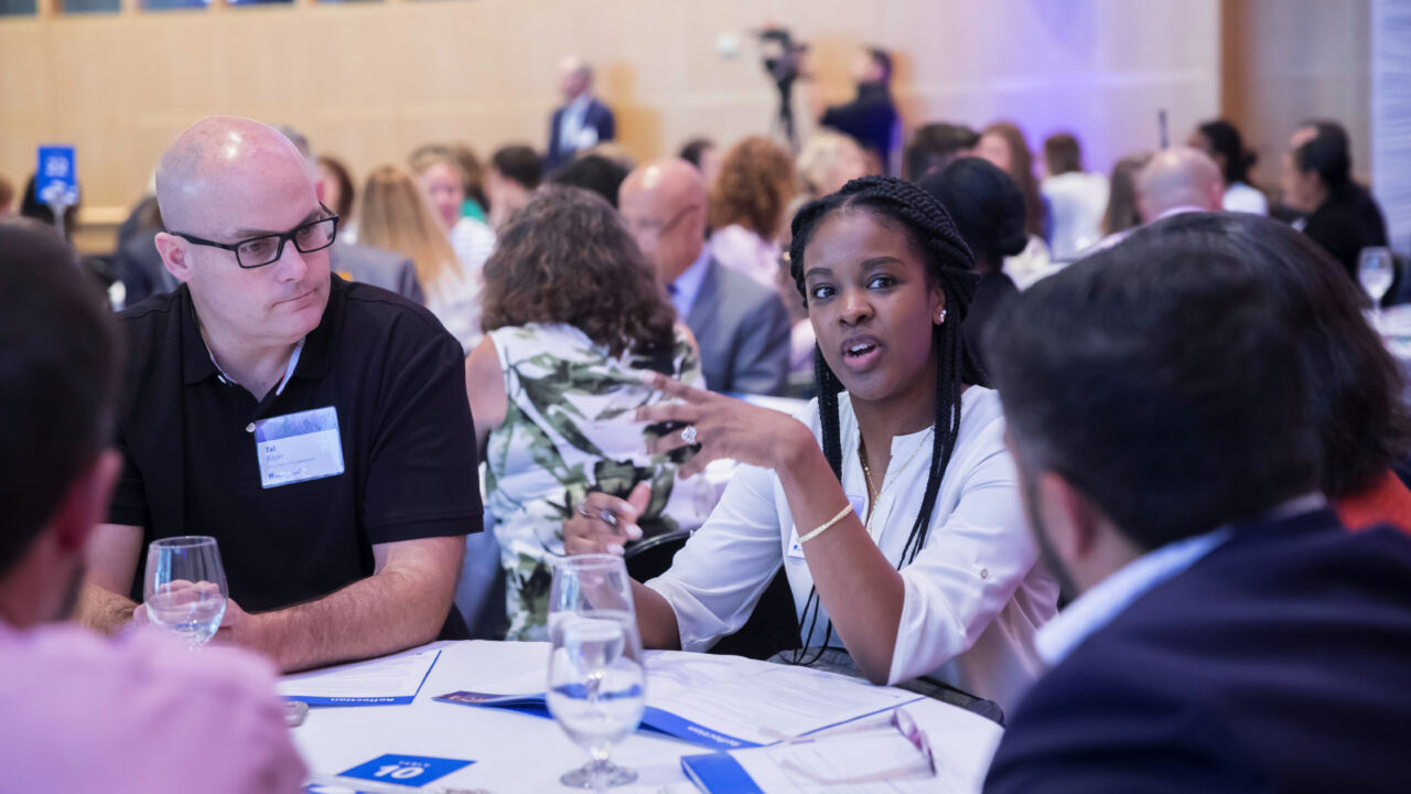 A woman speaks at a round table.
