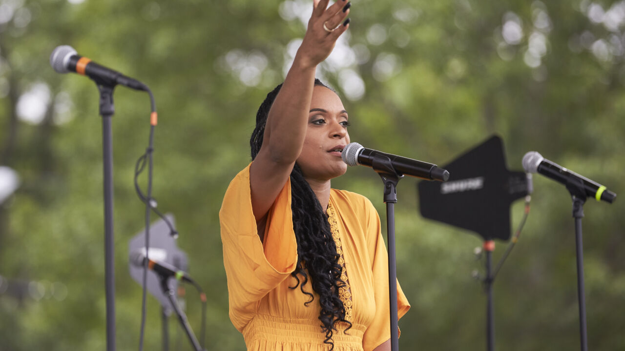 A woman sings on the stage at a concert.