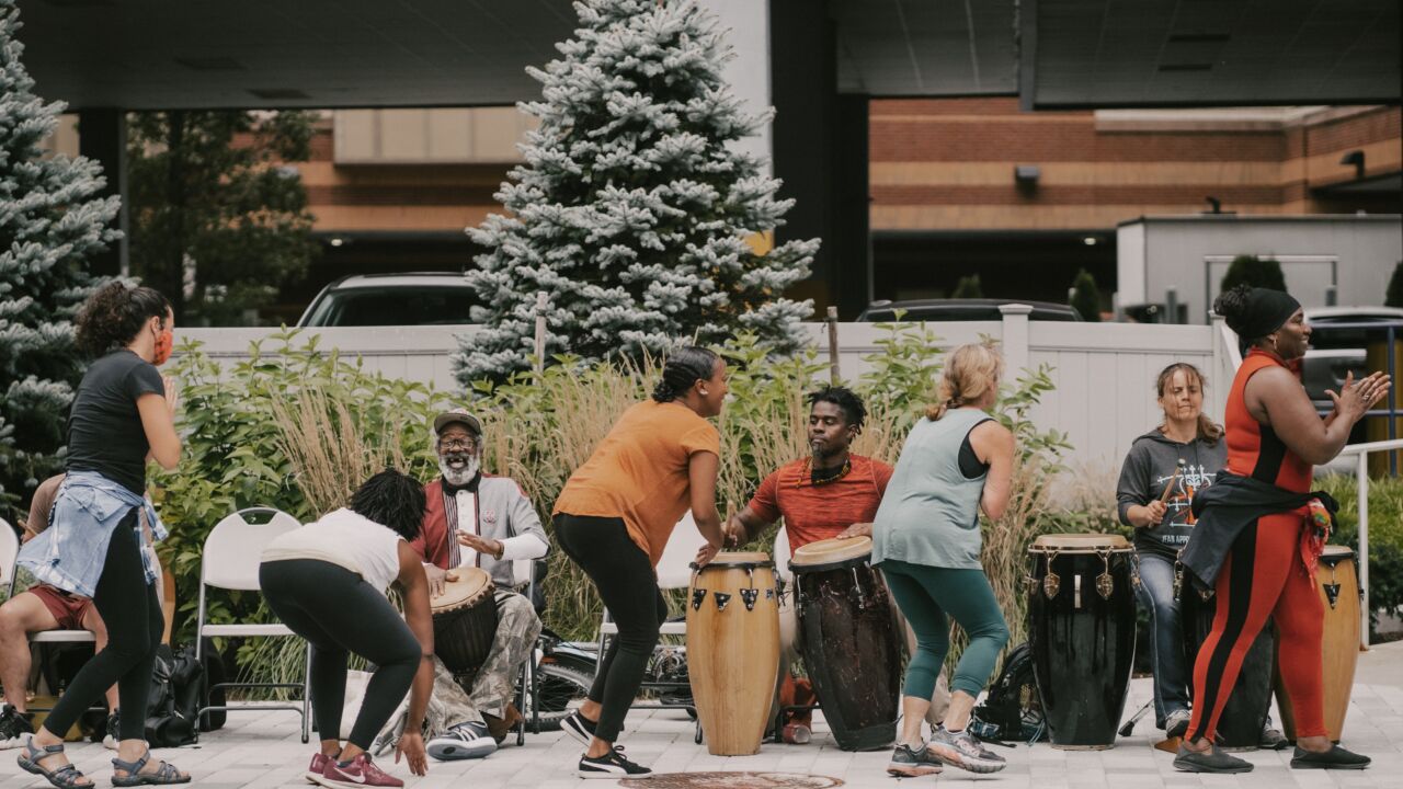 People making music in an outdoor public space using drums
