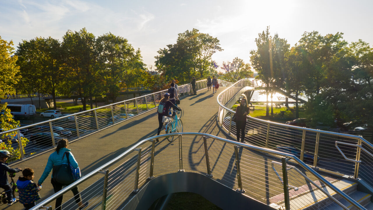 An aerial shot of a bridge and people walking their bikes over the bridge in downtown Boston.