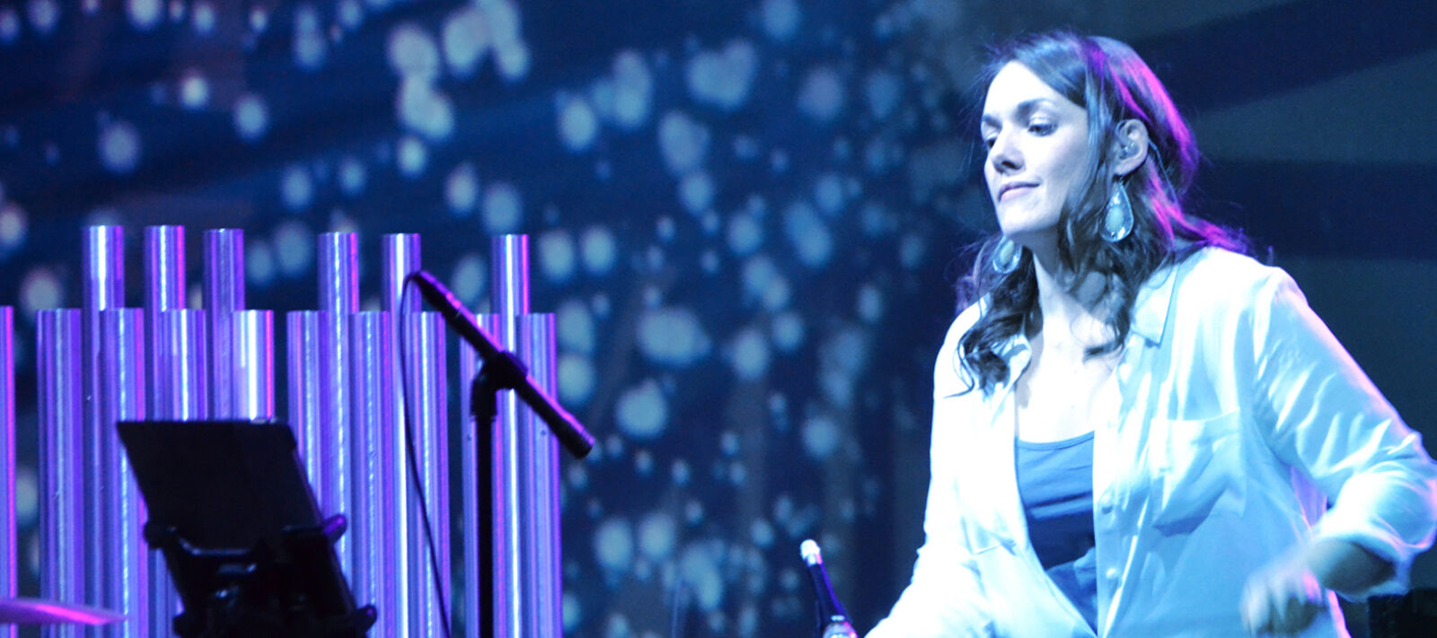 A musician plays the drums on stage.