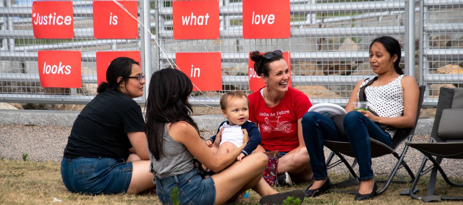 People eat and laugh at an outside picnic.