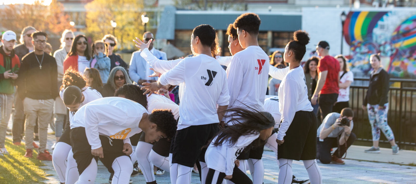 A group of teens dance outside.