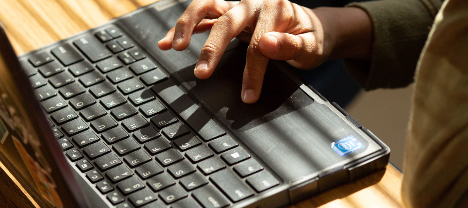 A student works at a laptop alone.