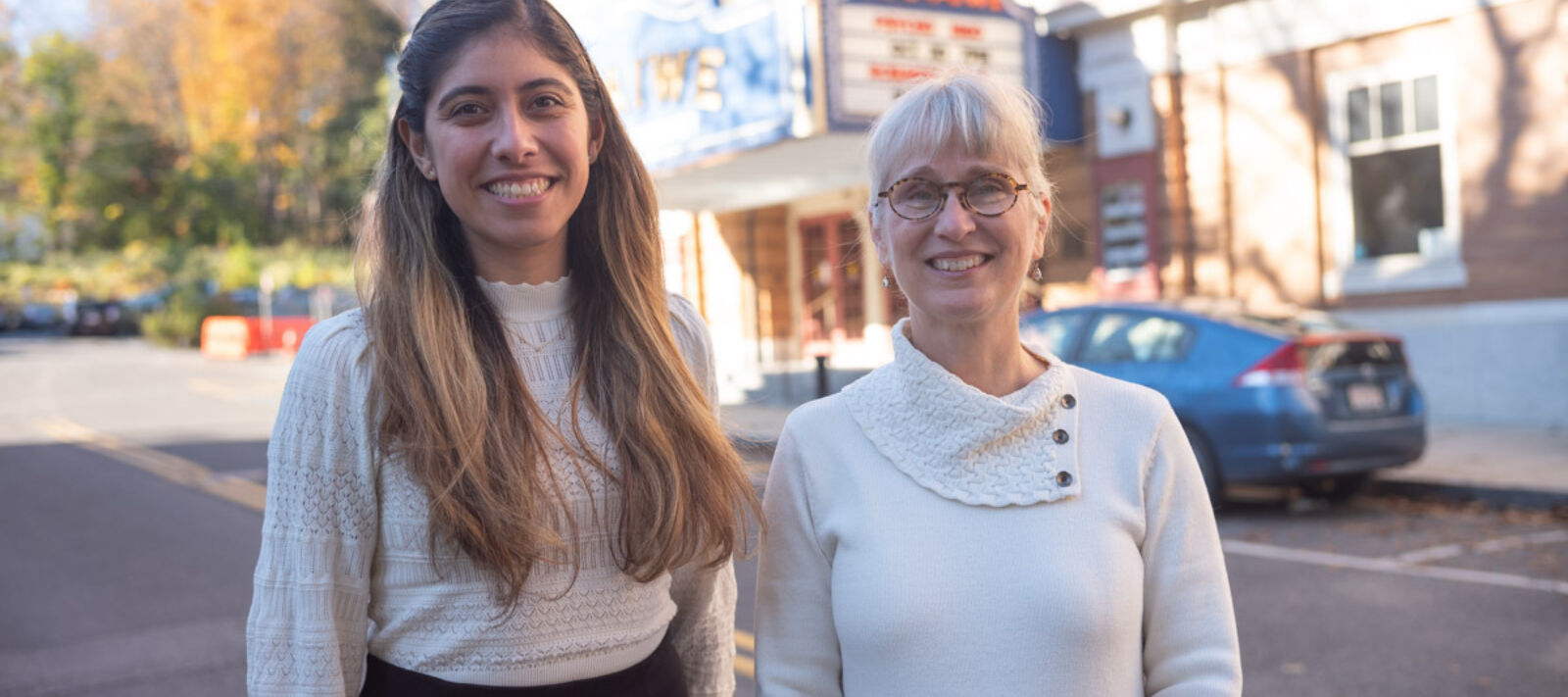 two woman standing outside in front of the Mahaiwe performing arts center smiling.