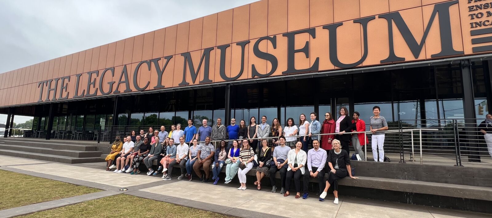 A posed group photo - roughly 40 people in two rows seated and standing