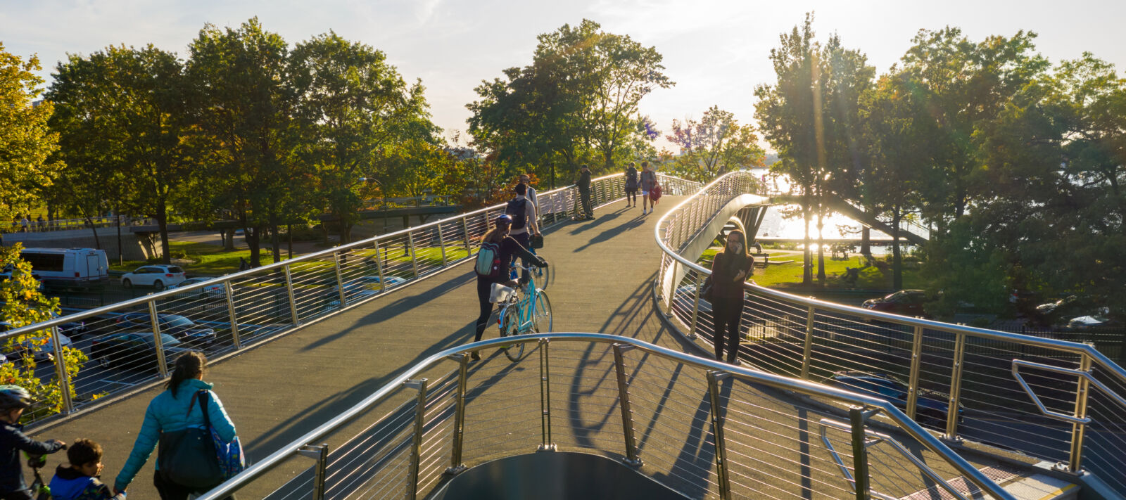 An aerial shot of a bridge and people walking their bikes over the bridge in downtown Boston.
